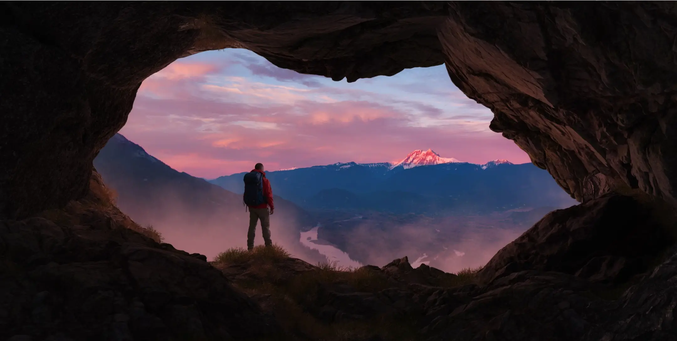 Une personne qui regarde un coucher de soleil à la montagne